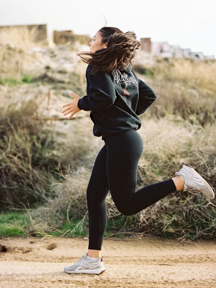 A runner on a dirt trail at golden hour