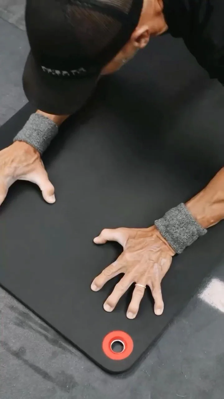 An athlete's hands planted on a mat mid push-up