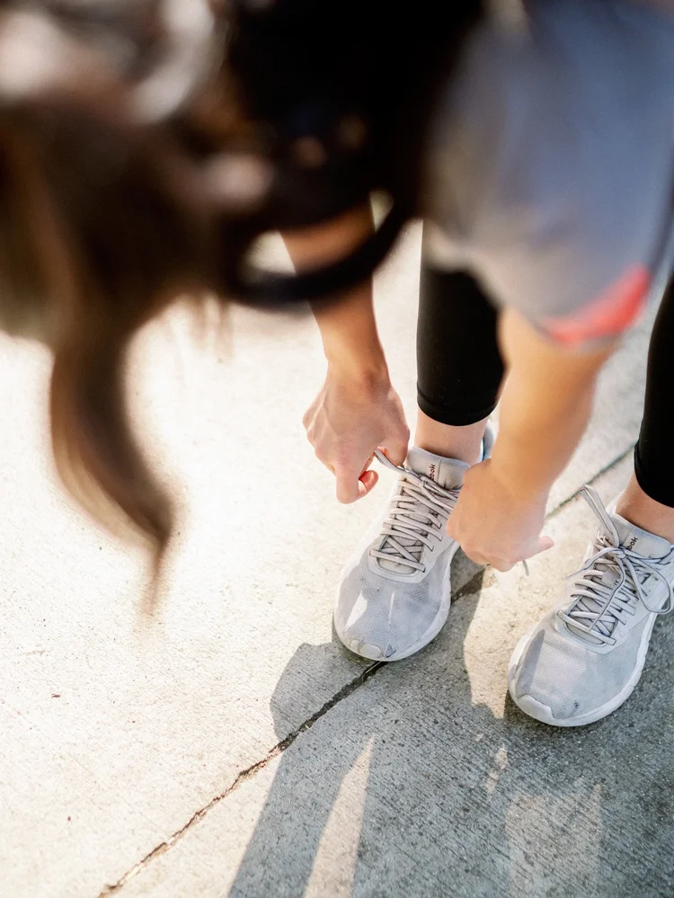 A motion-blurred close-up of running shoes striking pavement